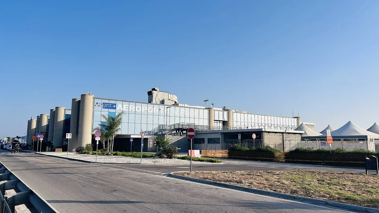 Il terminal dell'aeroporto di Trapani-Birgi Vincenzo Florio sotto un cielo sereno, con la strada di accesso in primo piano